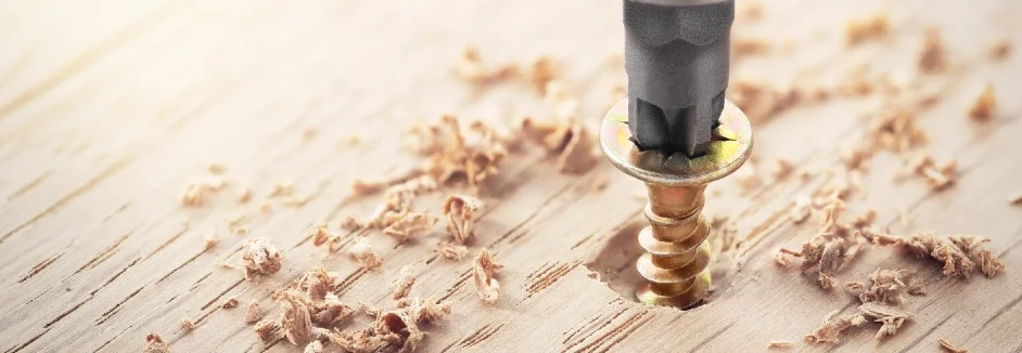 Schraubendreher dreht Schraube in Holz